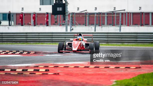 roten formel-rennwagen auf der strecke - formula 1 racing stock-fotos und bilder