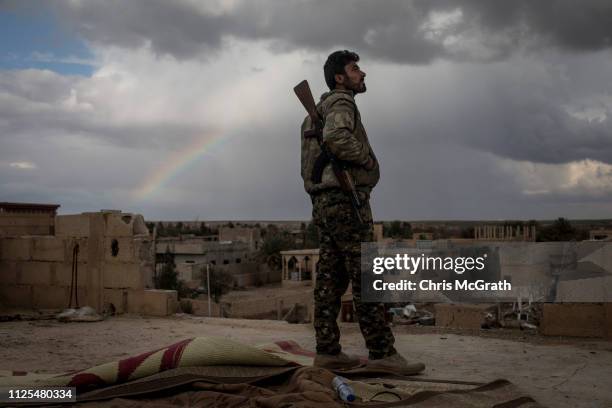 Fighters keep watch from a rooftop on the outskirts of Bagouz on February 17, 2019 in Bagouz, Syria. Fighting continues in a small section in the...