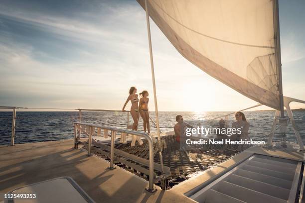 friends and family relaxing on boat deck at sunset - curaçao stock pictures, royalty-free photos & images