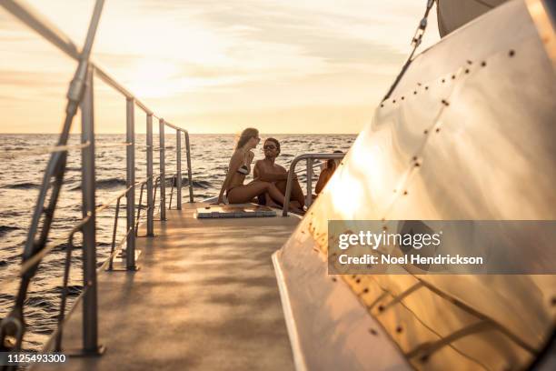 young couple enjoy romantic sunset on boat deck - catamaran sailing stock-fotos und bilder