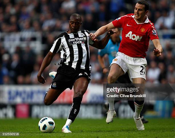 Shola Ameobi of Newcastle United competes with John O' Shea of Manchester United during the Barclays Premier League match between Newcastle United...