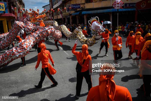 Participants seen performing with a replica a dragon during the festival. Cap Go Meh festival in downtown Singkawang, involves rituals of opening the...