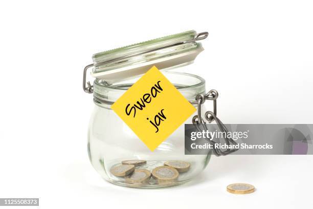 swear jar - doigt dhonneur fotografías e imágenes de stock