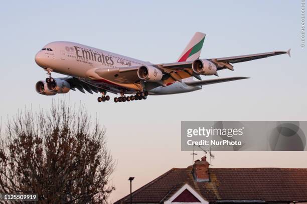 Emirates Airbus A380 shown landing at London Heathrow International Airport LHR / EGLL in England, UK over the residential area of Myrtle Avenue. The...