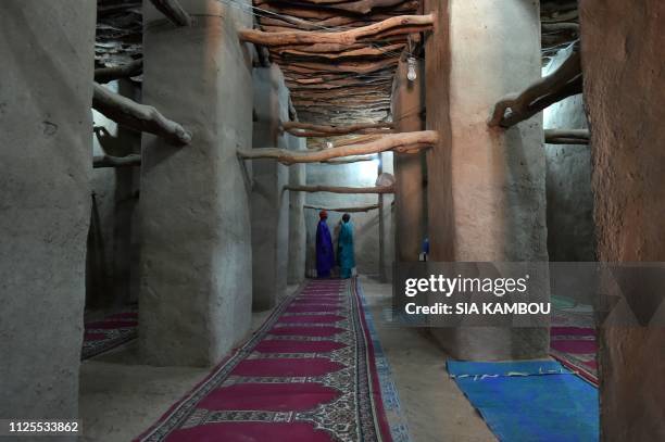 Muslim devotees talk after the prayer in the old mosque on January 23, 2019 in Kong, northern Ivory Coast, the home town of president Alassane...