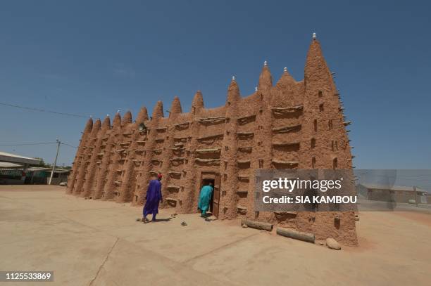 Muslim devotees walk into the old mosque to attend the prayer on January 23, 2019 in Kong, northern Ivory Coast, the home town of president Alassane...