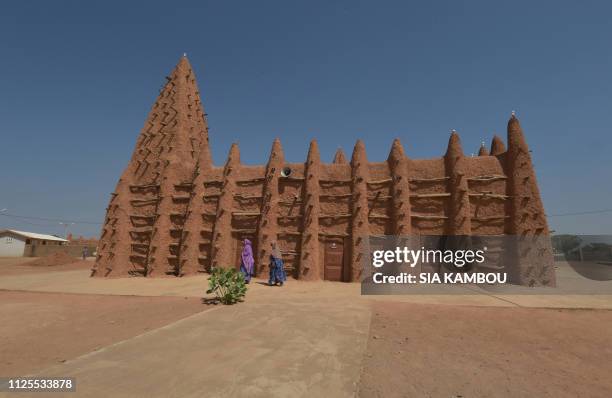 Muslim devotees walk into the old mosque to attend the prayer on January 23, 2019 in Kong, northern Ivory Coast, the home town of president Alassane...