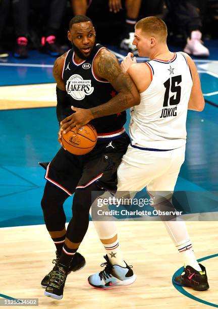 Team LeBron's LeBron James, of the Los Angeles Lakers, spins past Team Giannis' Nikola Jokic, of the Denver Nuggets, during the first half in the...