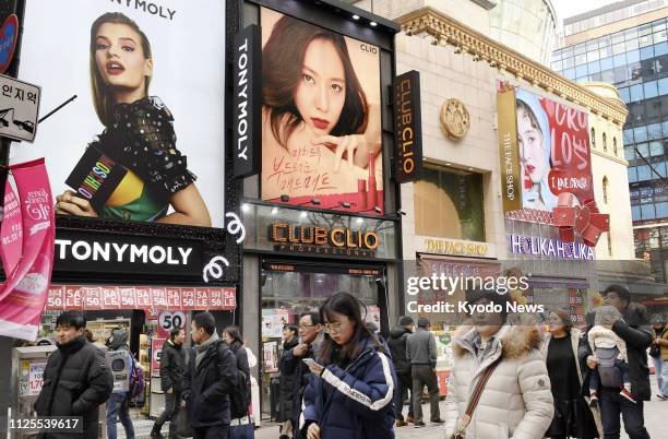 Photo taken on Feb. 8 shows a row of cosmetics stores in Seoul's Myeongdong commercial district, crowded with people including overseas tourists,...