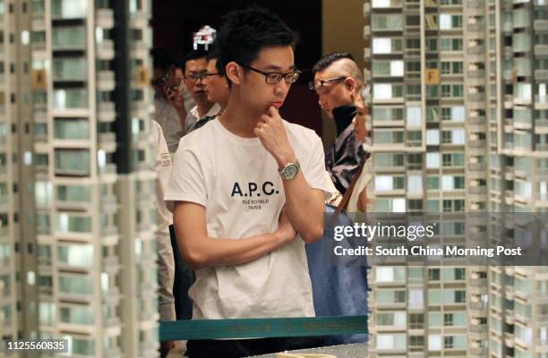 Potential buyers browse the model of The Reach, a residential project jointly developed by Henderson Land Development and New World Development at...