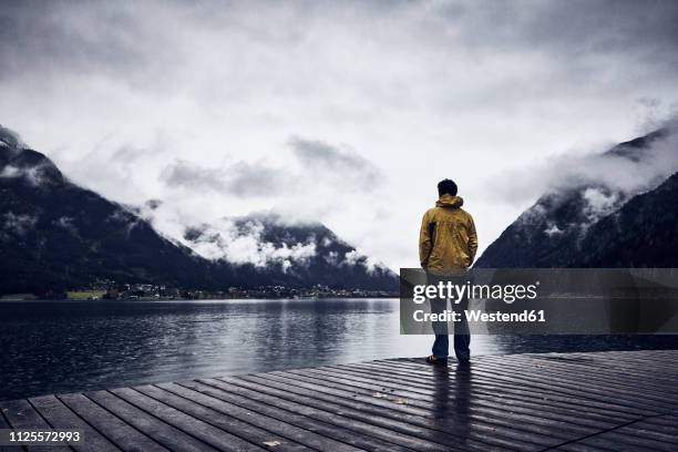 austria, tyrol, lake achen, man standing on boardwalk - depressie landelement stockfoto's en -beelden