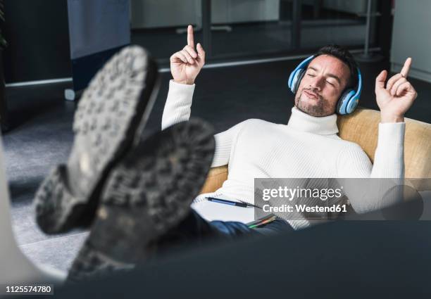 businessman listening relaxed music in his office - dirigent stock-fotos und bilder