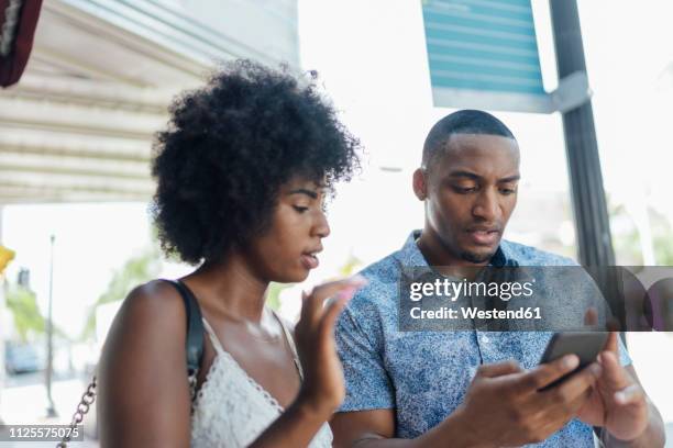 usa, florida, miami beach, young couple using cell phone in the city - angry on phone stockfoto's en -beelden
