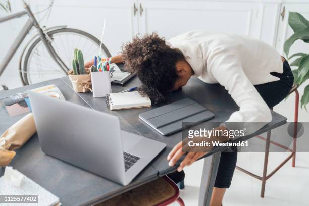 tired freelancer sleeping on her deak - frustration stock-fotos und bilder