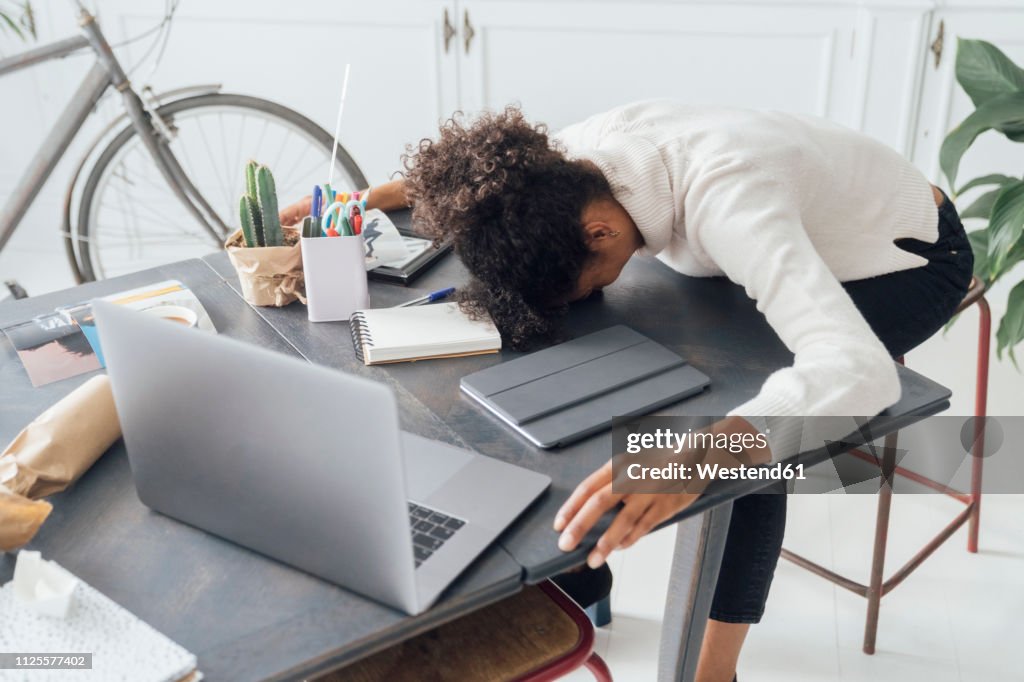 Tired freelancer sleeping on her deak