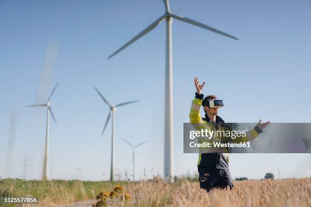 engineer standing in a field at a wind farm wearing vr glasses - new discovery stock pictures, royalty-free photos & images