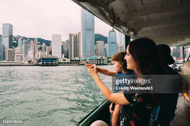 china, hong kong, mother and little daughter crossing the river by ferry from kowloon to hong kong island - hong kong family stockfoto's en -beelden