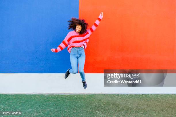 happy young woman jumping in the air - jump stockfoto's en -beelden
