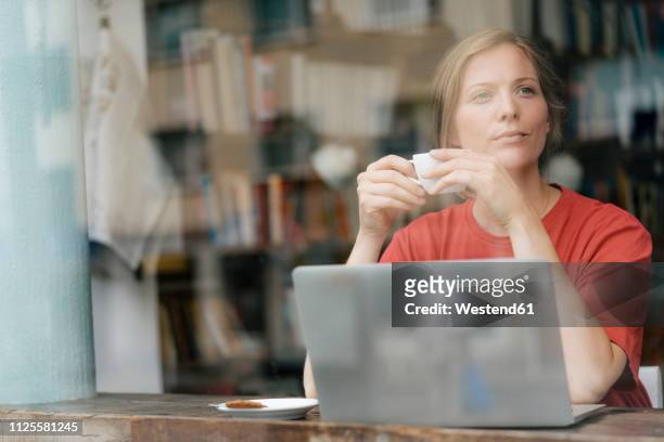 young woman with cup of coffee and laptop in a cafe - coffee top view stock-fotos und bilder