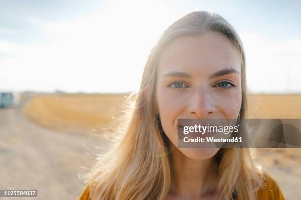 portrait of smiling young woman in rural landscape - young blonde woman facing away photos et images de collection