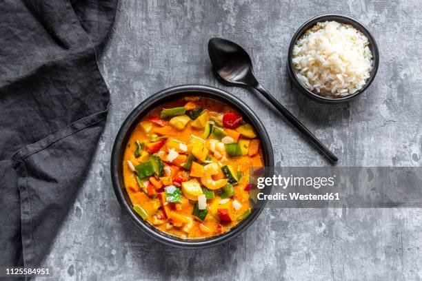 curry dish, sweet potato curry, sugar pea, paprika, zucchini, coconut milk, shrimps and rice - bowl of rice stockfoto's en -beelden