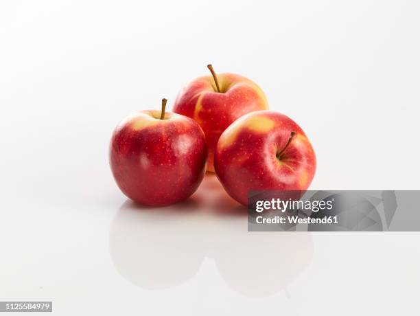 three red apples on white background - apple stockfoto's en -beelden