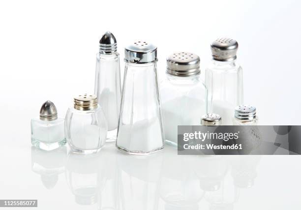 eight various salt shakjers ageinst white background - salt shaker stock pictures, royalty-free photos & images