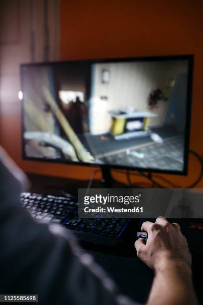 young man sitting at his pc, playing computer games - pre game stockfoto's en -beelden