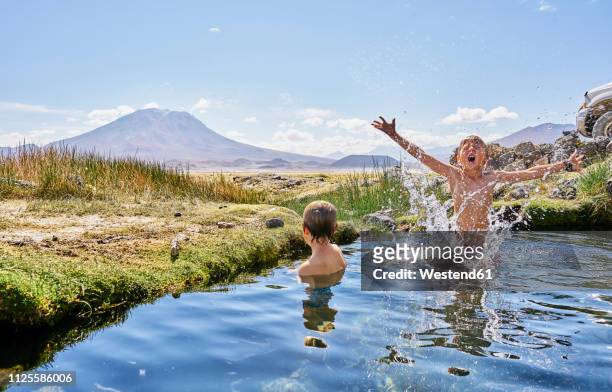 Chile, Salar del Carmen, two boys bathing in hot spring