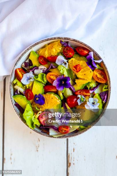 bowl of mixed salad with avocado, tomatoes and edible flowers - cabbage flower stock pictures, royalty-free photos & images