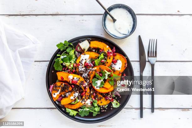 autumnal salad with fried pumpkin, lentils, radicchio, pomegranate seeds, leaf salad and parsley with dressing - dish top view stock pictures, royalty-free photos & images