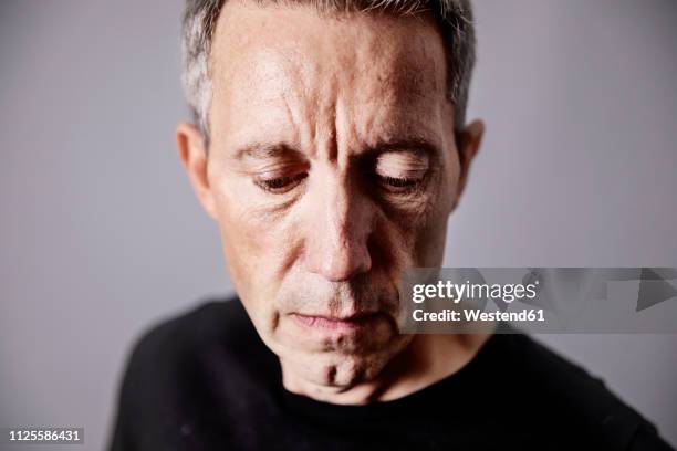 portrait of pensive mature man - blick nach unten stock-fotos und bilder