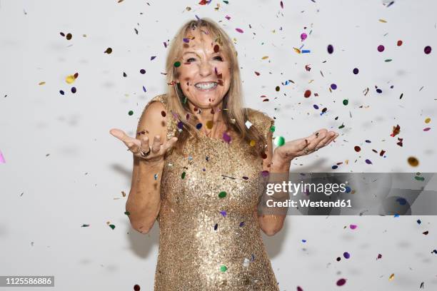 senior woman wearing golden dress, celebtraing new year's eve - new years eve party photos et images de collection