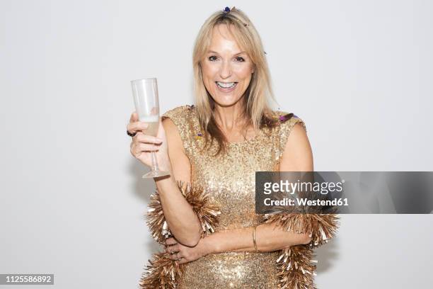 senior woman wearing golden dress, celebtraing new year's eve - evening gown stock-fotos und bilder