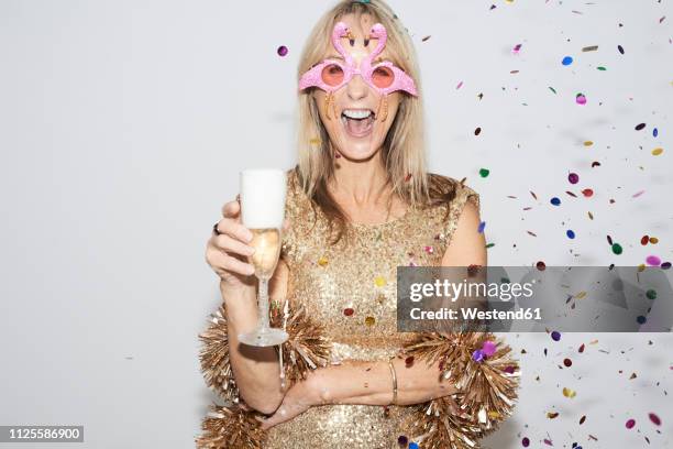 senior woman wearing golden dress and flmingo shaped glasses, celebtraing new year's eve - eve party stock pictures, royalty-free photos & images