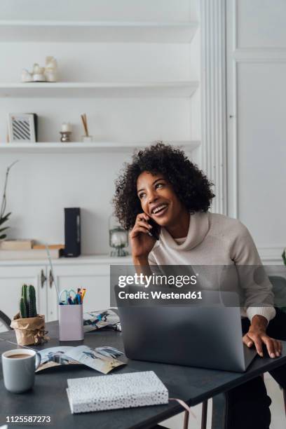 mid adult woman working in her home office, using smartphone - zzp'er bouw stockfoto's en -beelden