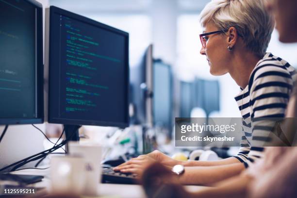 オフィスでコンピューター ソフトウェアに取り組んでいる若い女性プログラマーのプロフィール。 - 暗号化 ストックフォトと画像