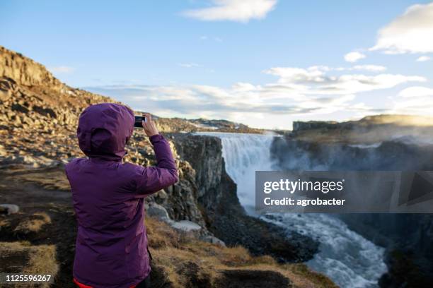 happy tourist against dettifoss waterfall background - canyon stock pictures, royalty-free photos & images