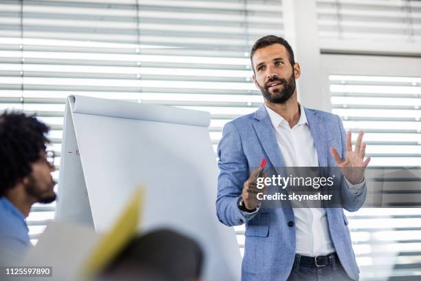 young manager talking on a business presentation in a board room. - presenter stock pictures, royalty-free photos & images