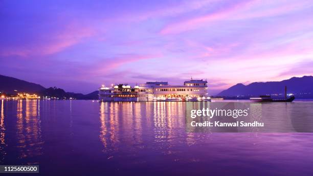 bluehour view of taj lake palace floating on lake pichola - udaipur palace stock-fotos und bilder