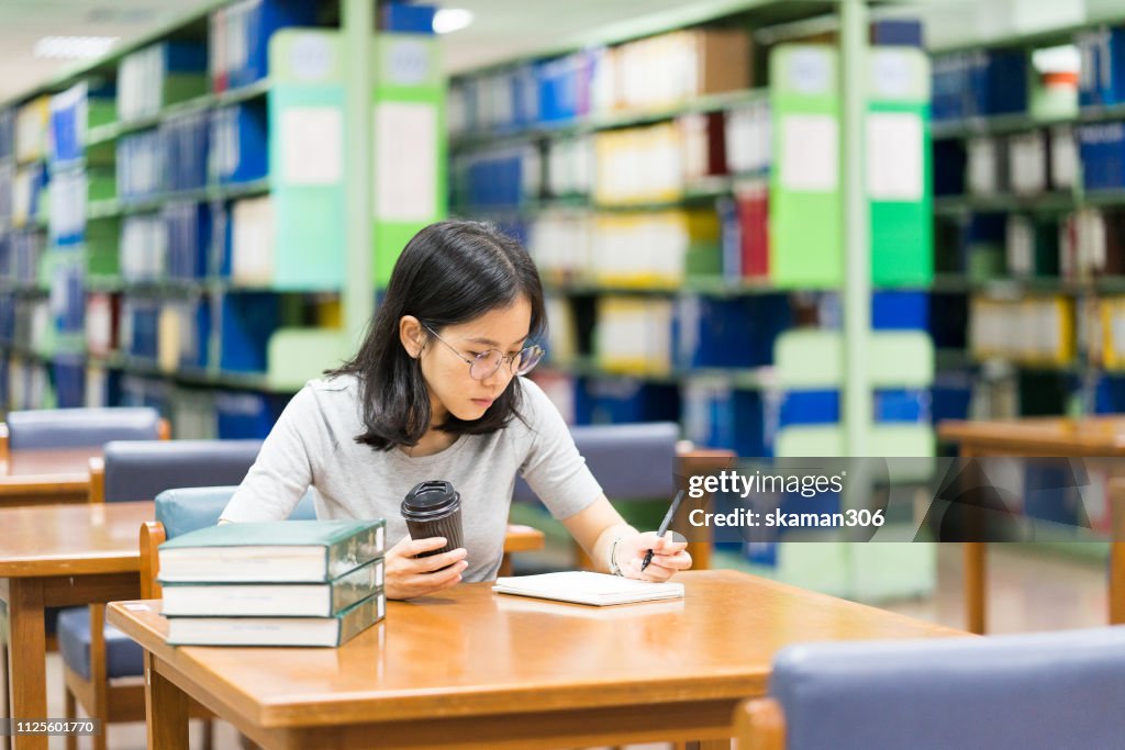 Asian student feeling stressed and crazy with homework at library near university