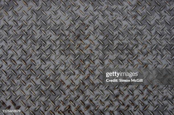 wet and rusty grey painted steel plate with cross-hatch non-slip texture pattern - non urban scene stockfoto's en -beelden