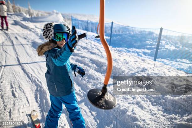 kleiner junge fangen einen aufhänger auf einen teller-skilift. - tellerlift stock-fotos und bilder
