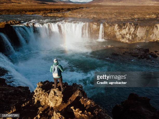 man looking at scenic view of waterfall in iceland - myvatn stock pictures, royalty-free photos & images