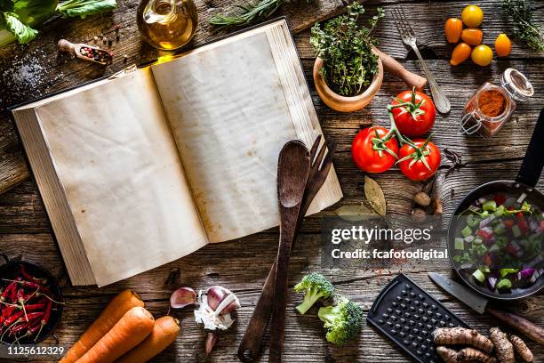 cookbook with vegetables, spices and herbs shot from above on rustic wooden table - cookbook stock pictures, royalty-free photos & images
