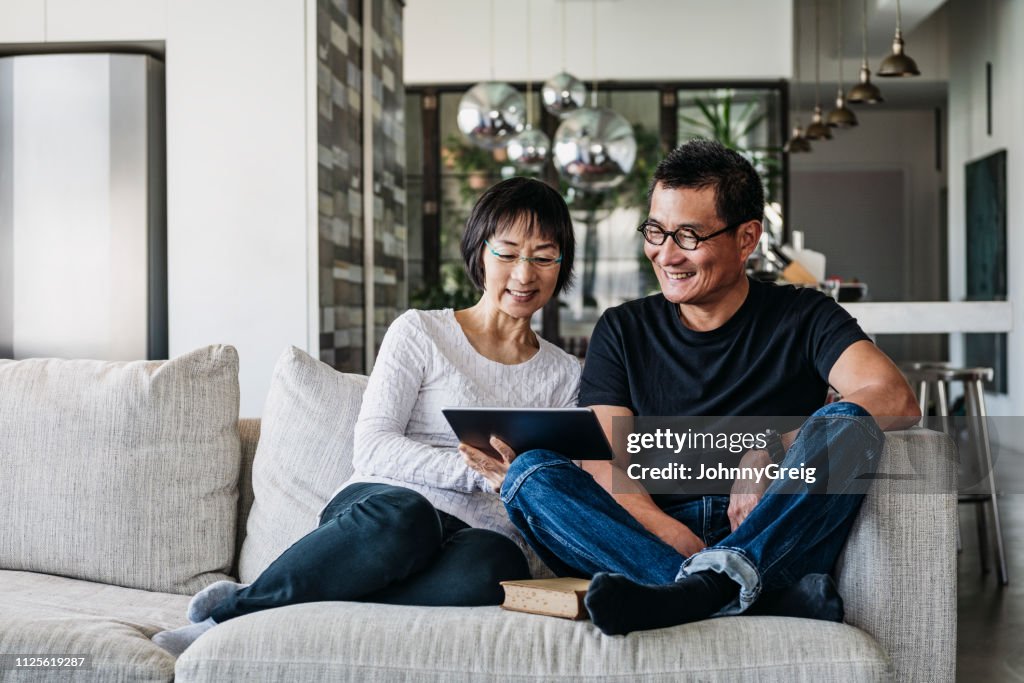 Chinese couple on sofa watching movie online