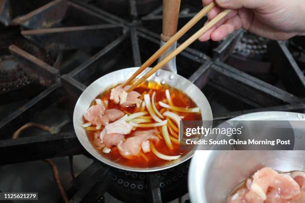 Imai Masakazu, Head Chef of Japanese restaurant Inakaya, demonstrates how to prepare oyakodon, a classic Japanese dish of simmered chicken and egg on...