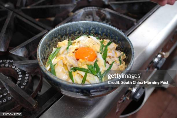 Imai Masakazu, Head Chef of Japanese restaurant Inakaya, demonstrates how to prepare oyakodon, a classic Japanese dish of simmered chicken and egg on...