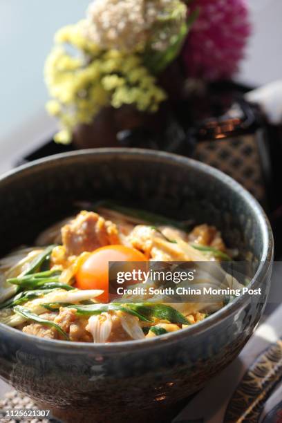 Imai Masakazu, Head Chef of Japanese restaurant Inakaya, demonstrates how to prepare oyakodon, a classic Japanese dish of simmered chicken and egg on...