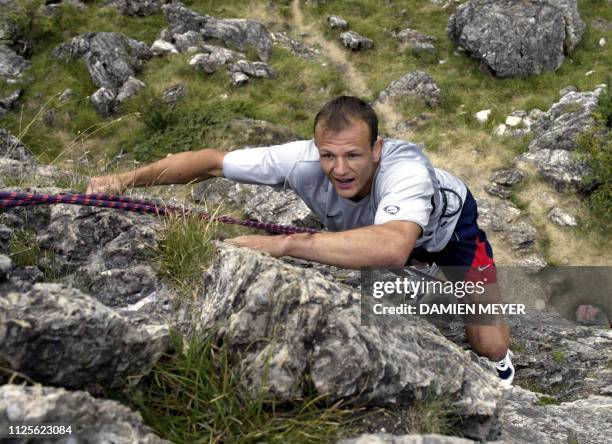 Le joueur du XV de France Patrick Tabacco monte une paroi le 04 août 2003 pendant une initiation à l'escalade près de Val d'Isère lors du stage en...